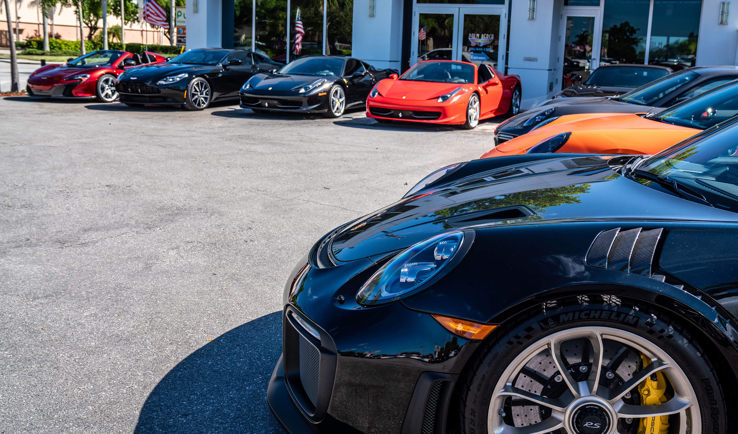 Exterior image of Palm Beach Auto Group dealership: front of store with exotic cars.